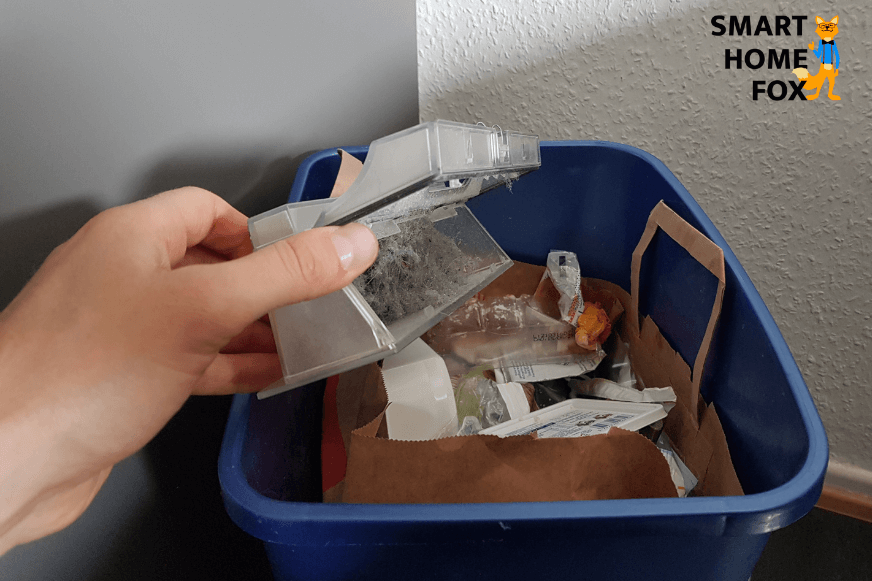 Der Schmutzbehälter des Roborock Saugroboters wird über einem Mülleimer ausgeleert